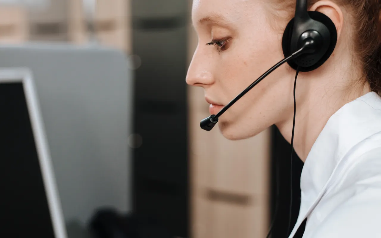 Medewerker met headset tijdens klantcontact
