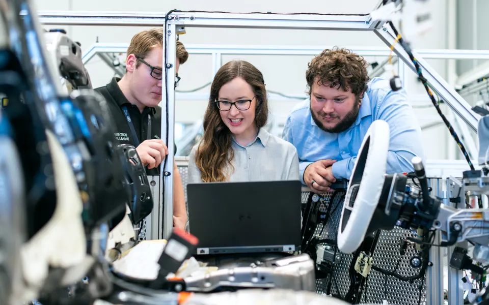 Technici overleggen bij een voertuig in een werkplaats