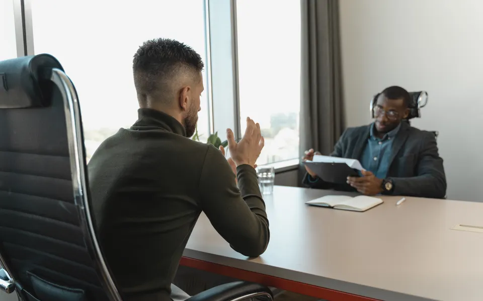 Twee mensen in gesprek aan een bureau