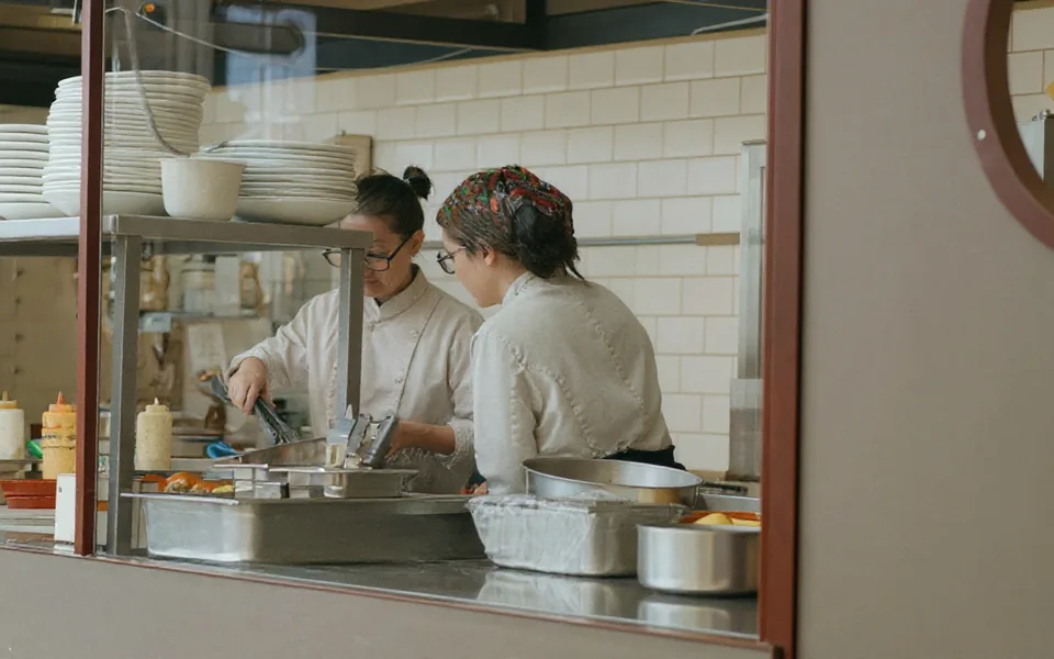AI-edited stock photograph: two chefs work together in a restaurant kitchen.